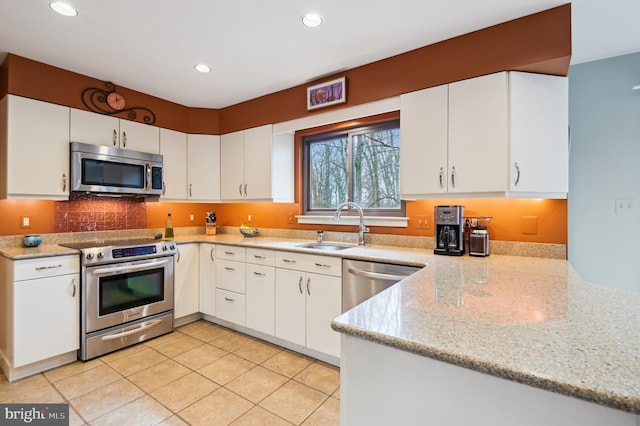 kitchen with white cabinetry, stainless steel appliances, a sink, and recessed lighting