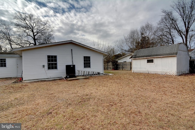 back of property featuring an outdoor structure and a lawn