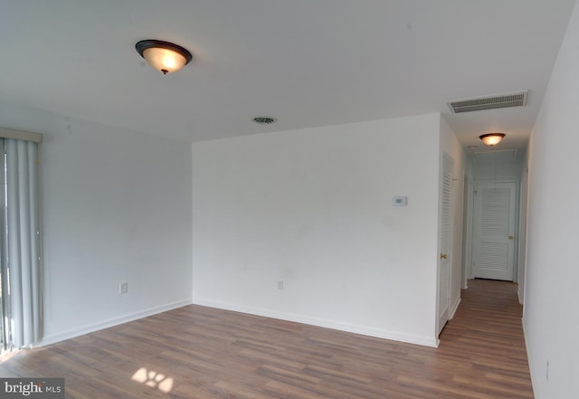 unfurnished room with dark wood-type flooring