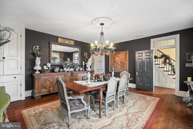 dining space featuring dark hardwood / wood-style floors and a chandelier