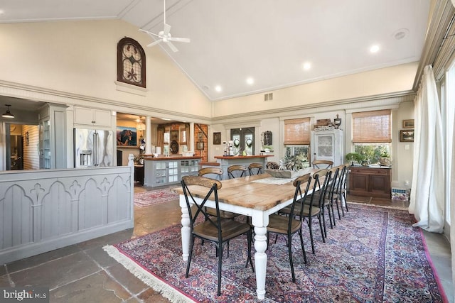 dining room with ceiling fan and high vaulted ceiling