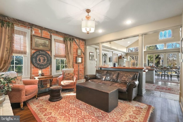 living room featuring ornate columns, lofted ceiling, and dark hardwood / wood-style floors