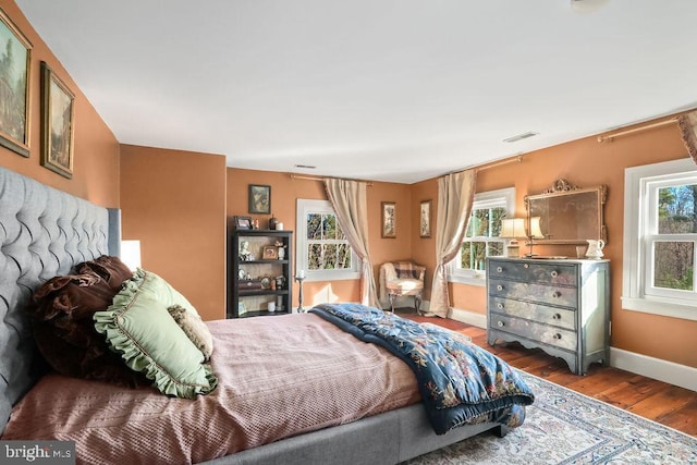 bedroom with multiple windows and wood-type flooring