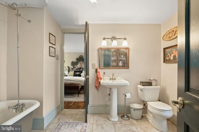 bathroom with sink, toilet, tile patterned flooring, and a bathtub