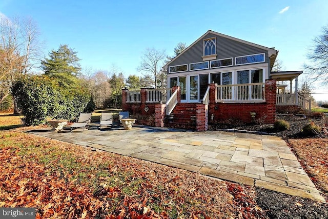 rear view of property featuring a patio area and a sunroom