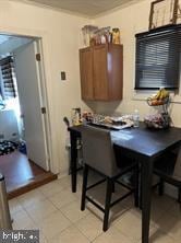 dining area with light tile patterned floors and ornamental molding