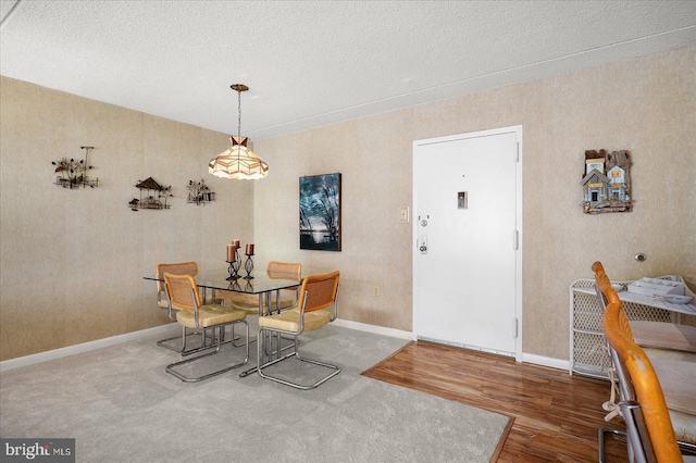 dining room with hardwood / wood-style flooring and a textured ceiling