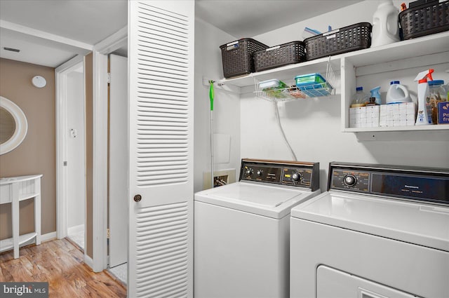 washroom featuring washing machine and clothes dryer and light wood-type flooring