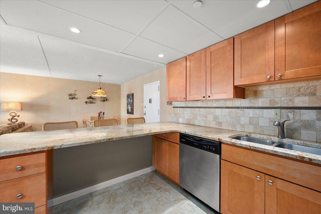 kitchen featuring sink, light stone counters, hanging light fixtures, dishwasher, and kitchen peninsula