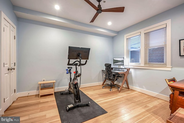 exercise room with ceiling fan and light hardwood / wood-style flooring