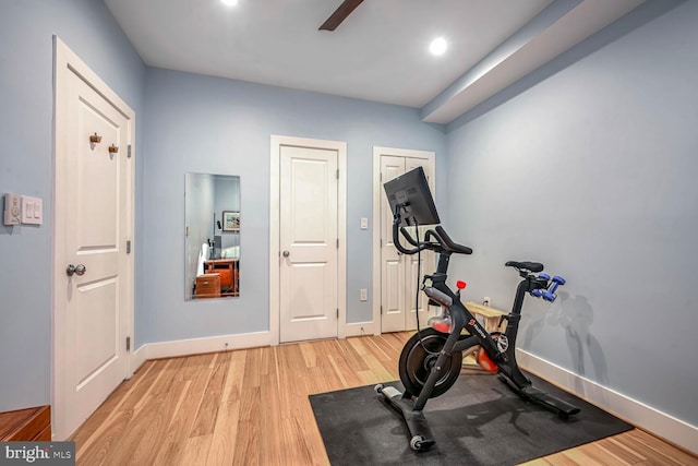 exercise area with ceiling fan and light hardwood / wood-style floors