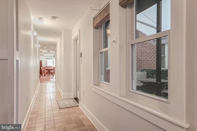 hall with light tile patterned floors