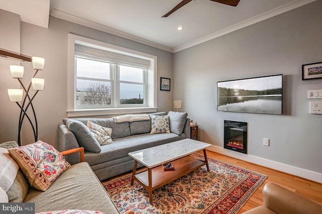 living room with crown molding, wood-type flooring, and ceiling fan