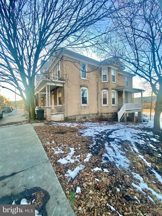 snow covered property featuring covered porch