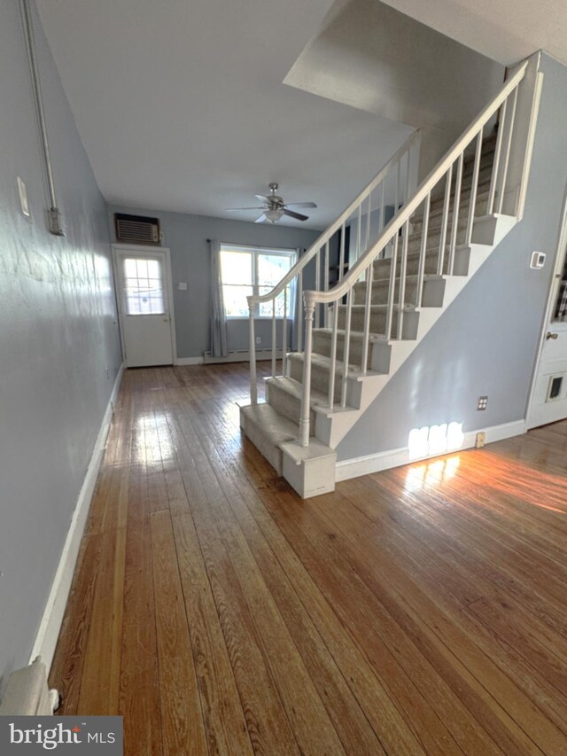 interior space featuring wood-type flooring, ceiling fan, and baseboard heating