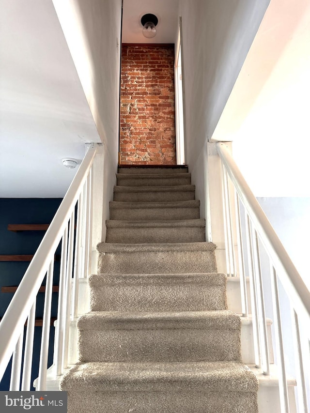 stairs featuring brick wall