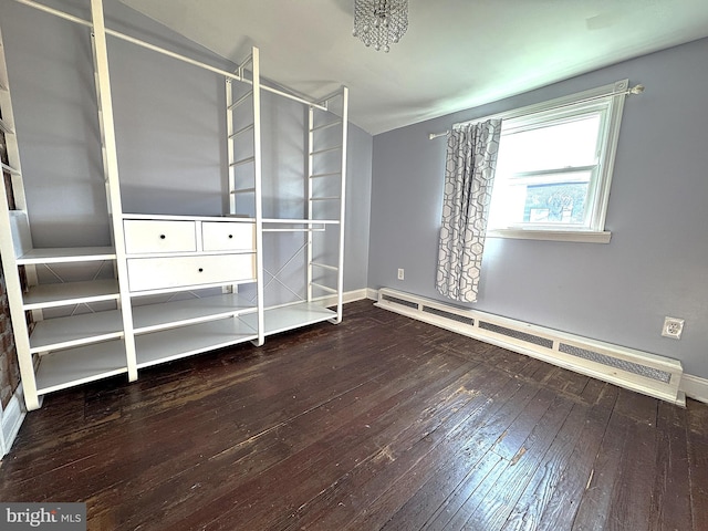 unfurnished bedroom with baseboard heating and hardwood / wood-style floors