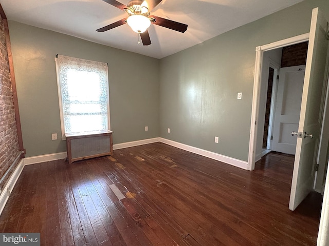 unfurnished bedroom featuring ceiling fan and dark hardwood / wood-style flooring