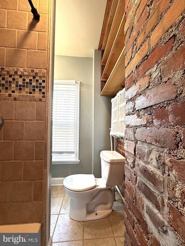 bathroom with brick wall and toilet