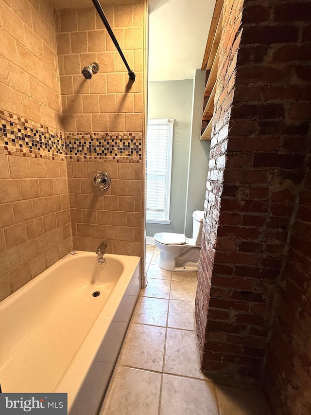 bathroom with tiled shower / bath combo, tile patterned floors, and toilet