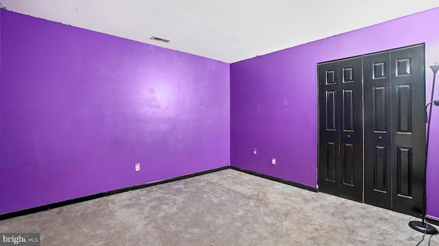 unfurnished bedroom with a closet and light colored carpet