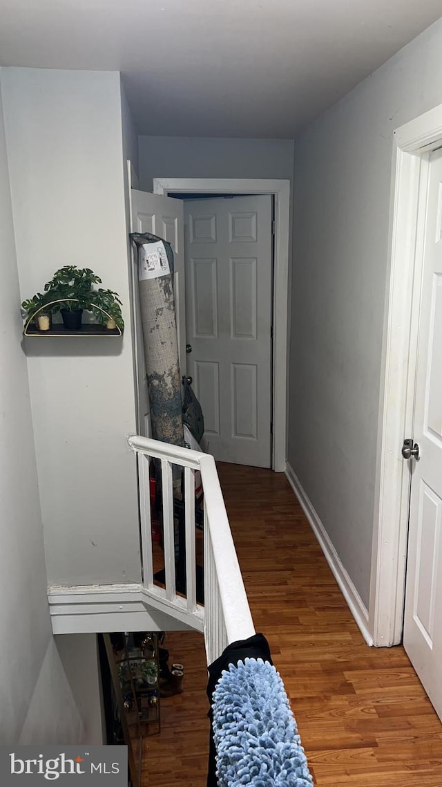 corridor with hardwood / wood-style floors