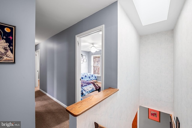 corridor featuring a skylight and carpet flooring