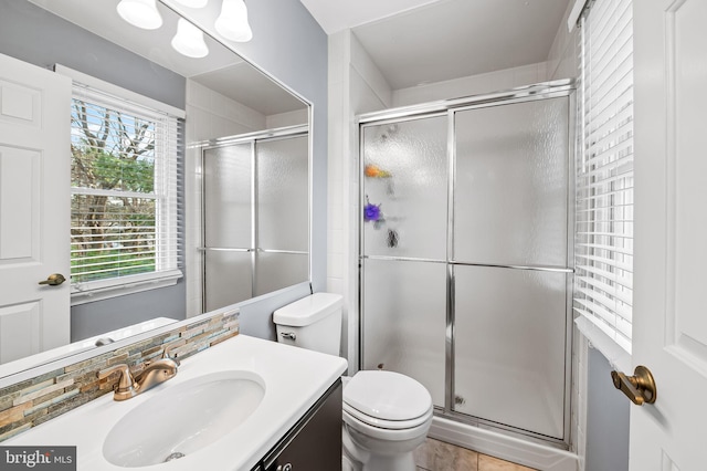 bathroom with vanity, toilet, and a shower with shower door