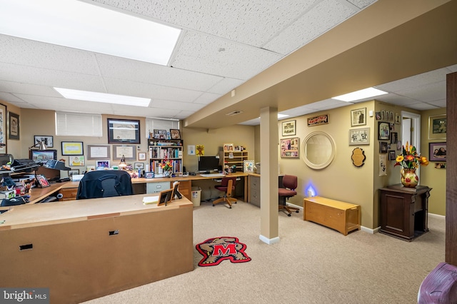 carpeted office space featuring a paneled ceiling