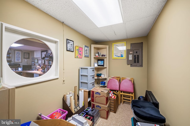 rec room with light colored carpet, a paneled ceiling, and electric panel