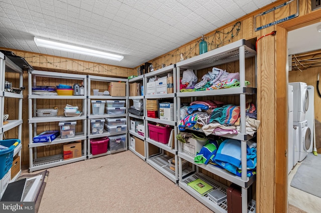 storage area featuring stacked washer and clothes dryer