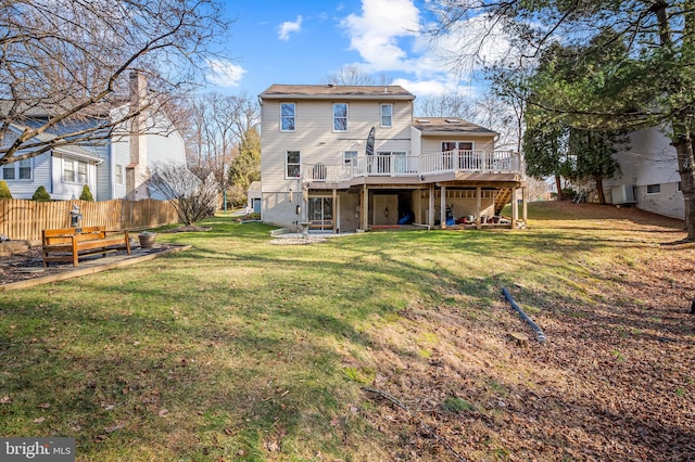 back of property with a deck and a lawn