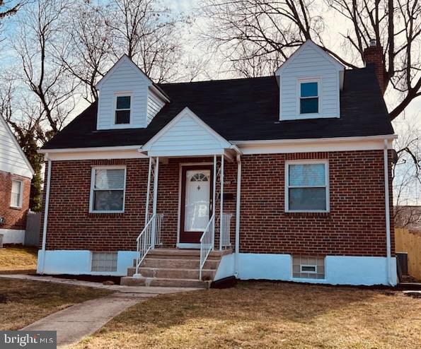 cape cod house with a front yard, brick siding, and entry steps