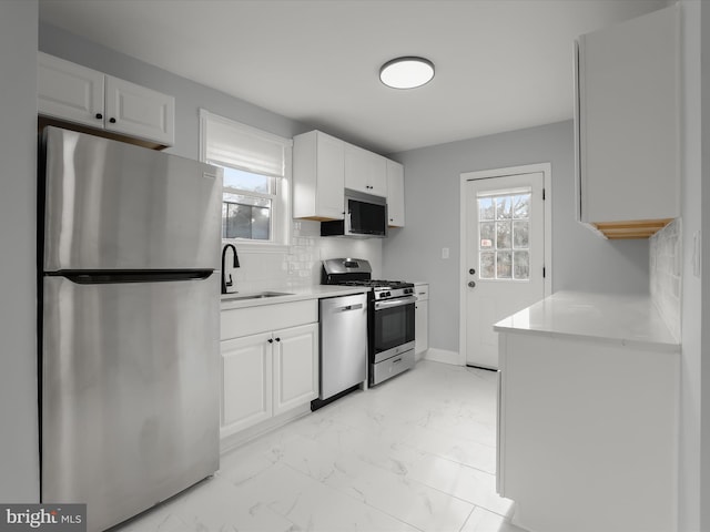 kitchen featuring appliances with stainless steel finishes, white cabinets, and light countertops