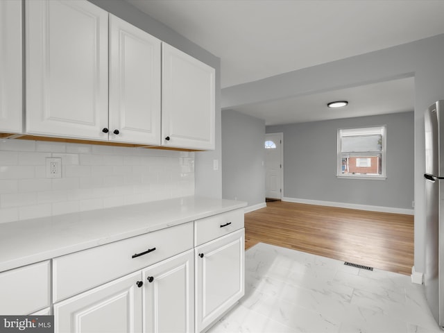 kitchen with visible vents, light countertops, and white cabinetry