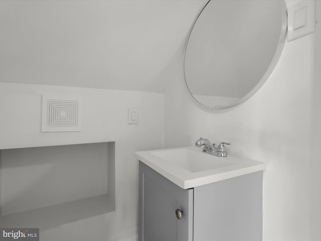 bathroom with lofted ceiling and vanity