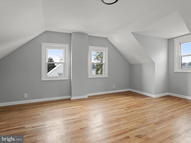 additional living space featuring baseboards, lofted ceiling, and light wood-style floors