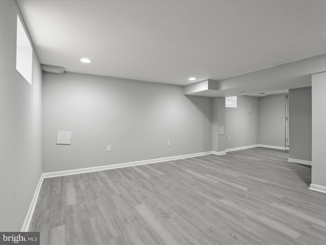 finished basement with light wood-type flooring, baseboards, and recessed lighting