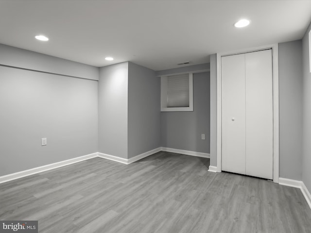 finished below grade area featuring recessed lighting, light wood-type flooring, visible vents, and baseboards