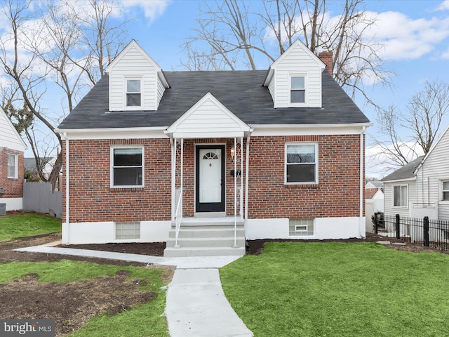 new england style home with brick siding, fence, a chimney, and a front lawn