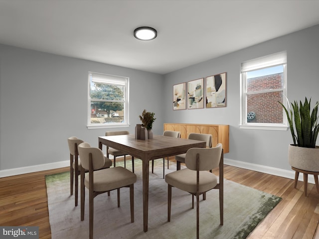 dining room featuring light wood finished floors and baseboards