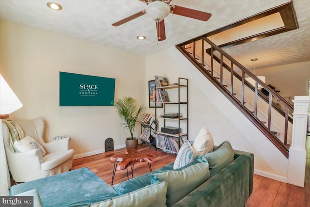 living room with wood-type flooring and ceiling fan