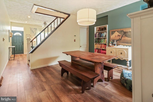 dining room with hardwood / wood-style flooring, ceiling fan, and built in features