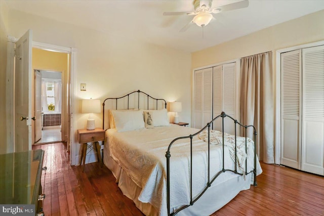 bedroom with multiple closets, ceiling fan, and hardwood / wood-style flooring