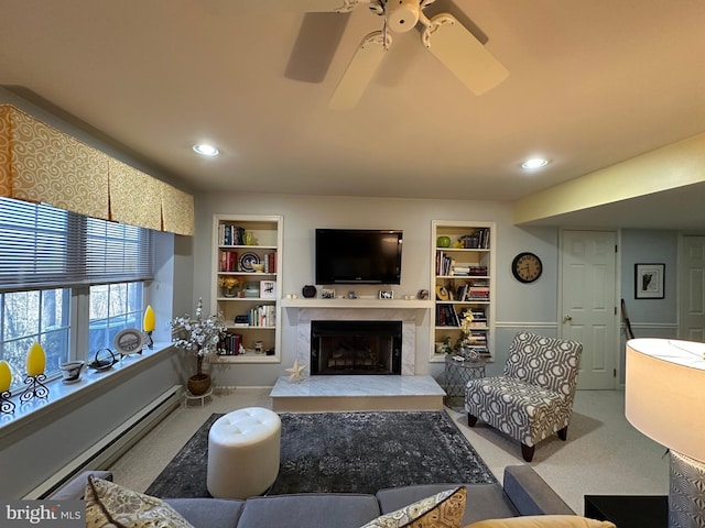 carpeted living room featuring baseboard heating, ceiling fan, a fireplace, and built in features