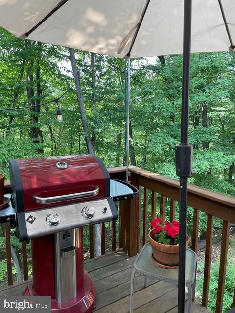 wooden terrace featuring a grill