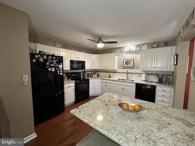 kitchen with sink, white cabinets, decorative backsplash, light stone counters, and black appliances