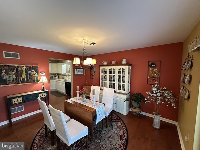 dining room with an inviting chandelier, dark hardwood / wood-style floors, and sink