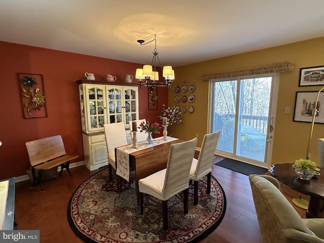 dining area with dark hardwood / wood-style floors and a chandelier