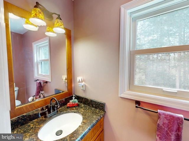 half bathroom featuring vanity and toilet